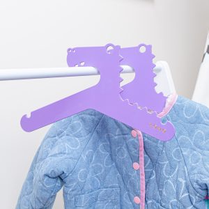 purple designer Kids hanger dinosaur shaped on a rack